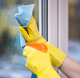Мытье окна чистящим средством в перчатках